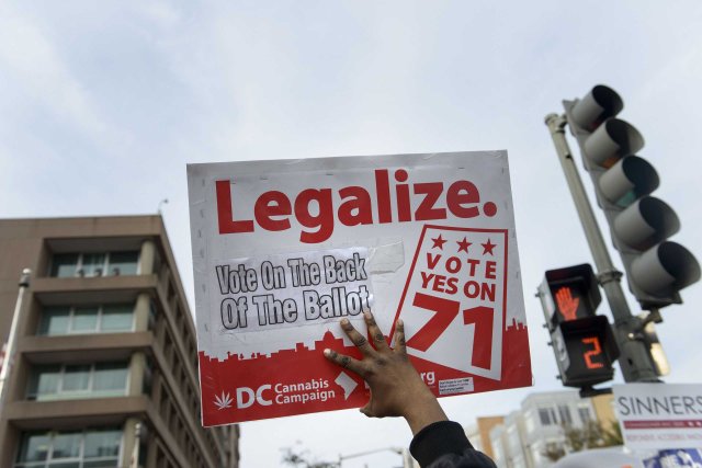 A man holds up a sign for Ballot Initiative #71, the legalization of marijuana, in Washington, D.C., on Nov. 4, 2014.